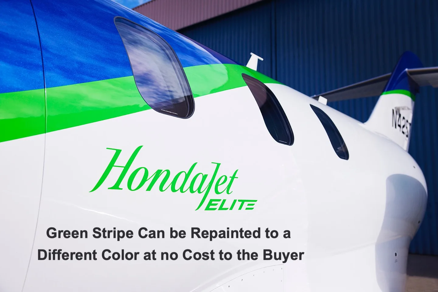 Close-up of the fuselage of a HondaJet Elite, showing the blue and green stripe and "HondaJet ELITE" branding.