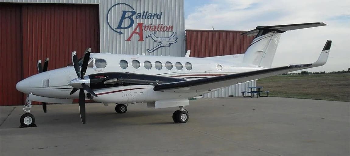 A Beechcraft King Air 350 is parked outside a hangar.