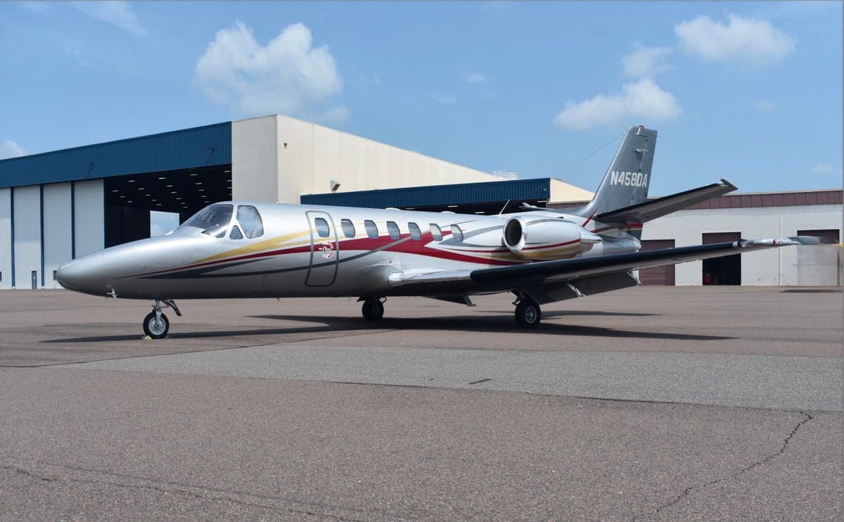 A silver and red Cessna Citation CJ3+ on the ramp.