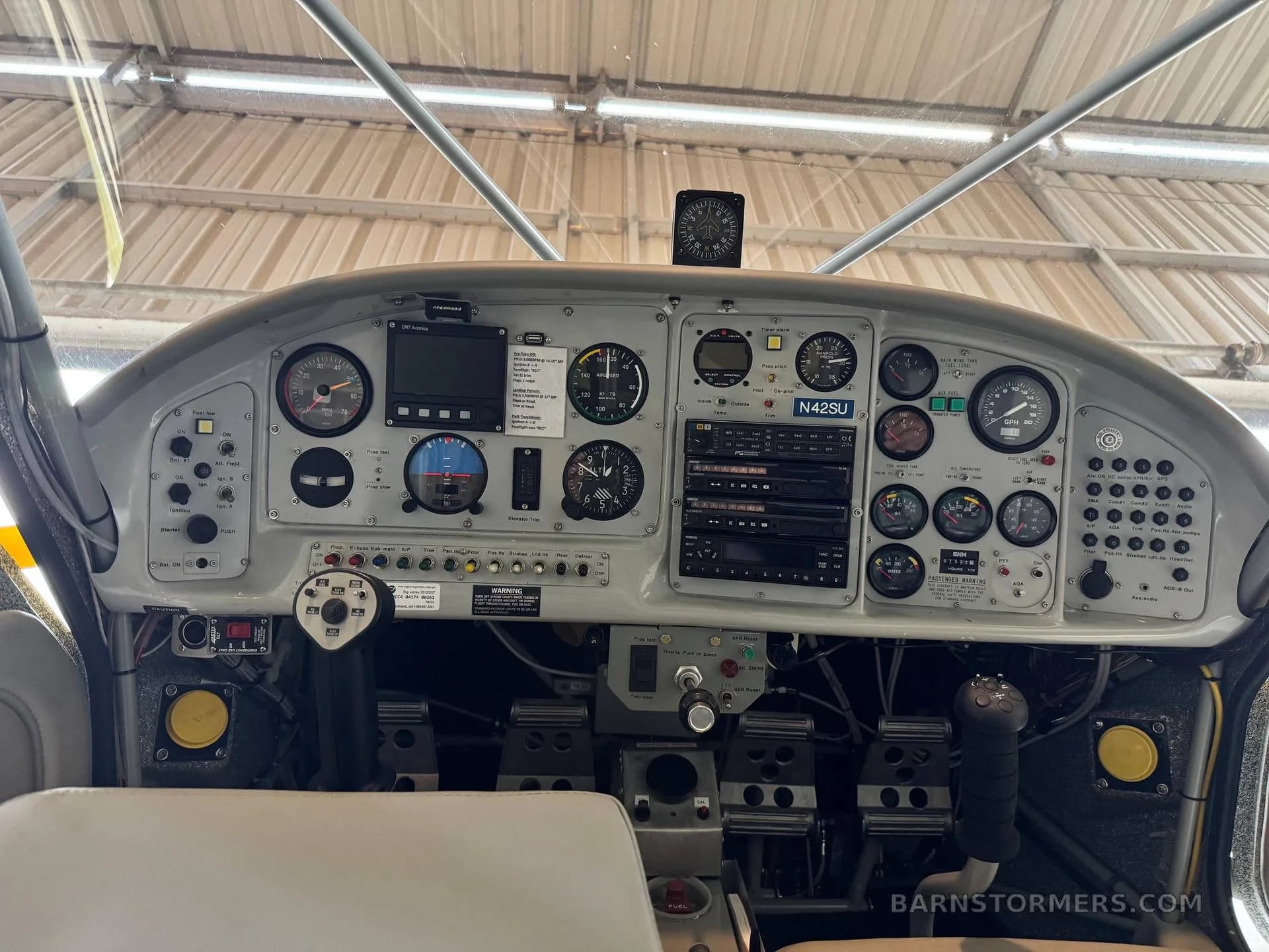 The detailed instrument panel of a light aircraft, featuring various gauges, screens, and controls, with the registration N42SU visible.