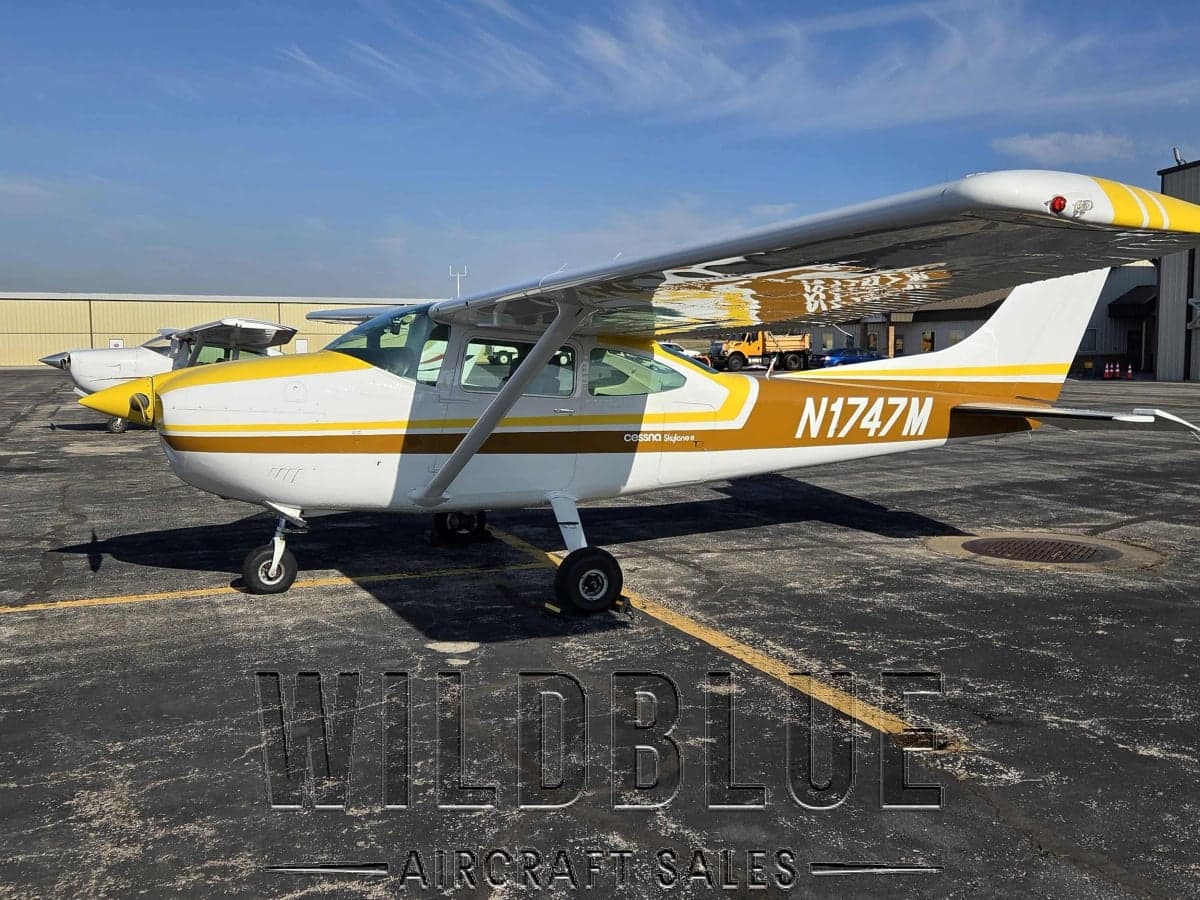 N1747M Cessna Skyhawk with white and gold paint scheme on the tarmac with Wildblue Aircraft Sales watermark.