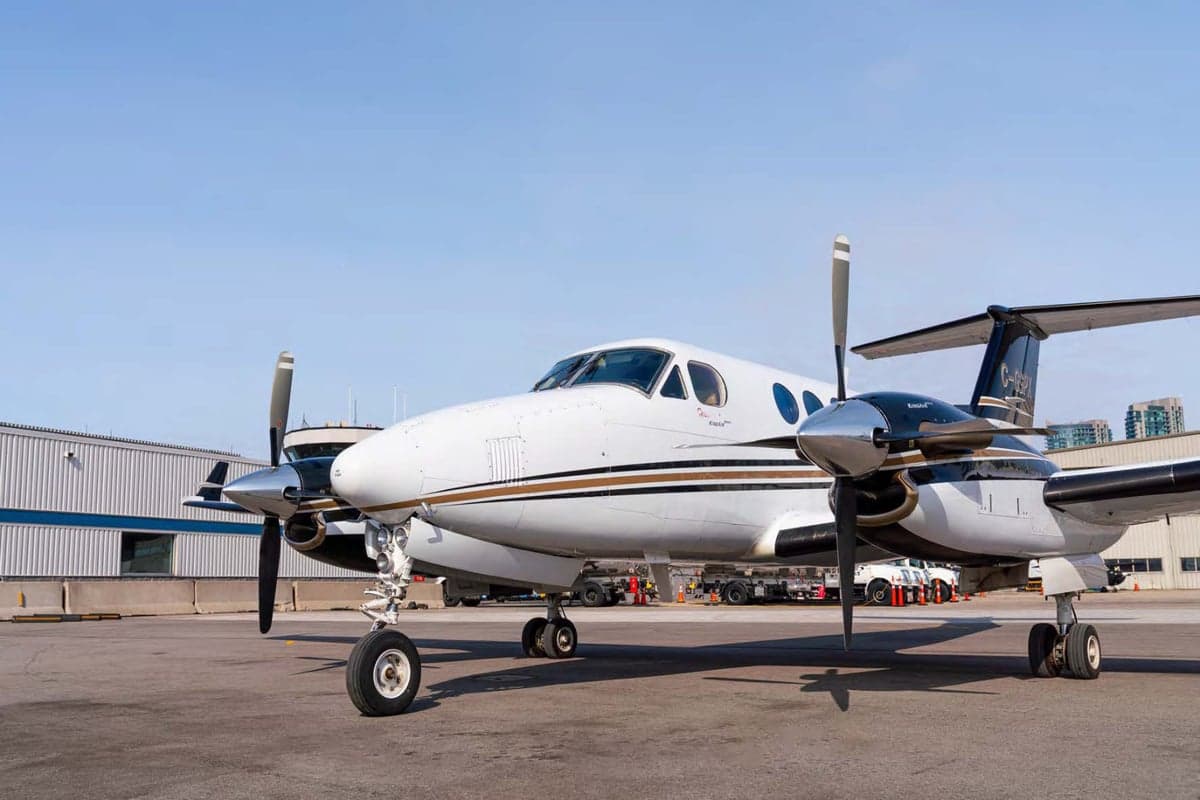 A King Air aircraft is parked on the tarmac, showcasing its white and brown paint scheme.