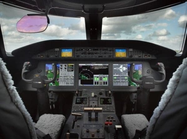 View of the aircraft cockpit with multiple display screens and controls.