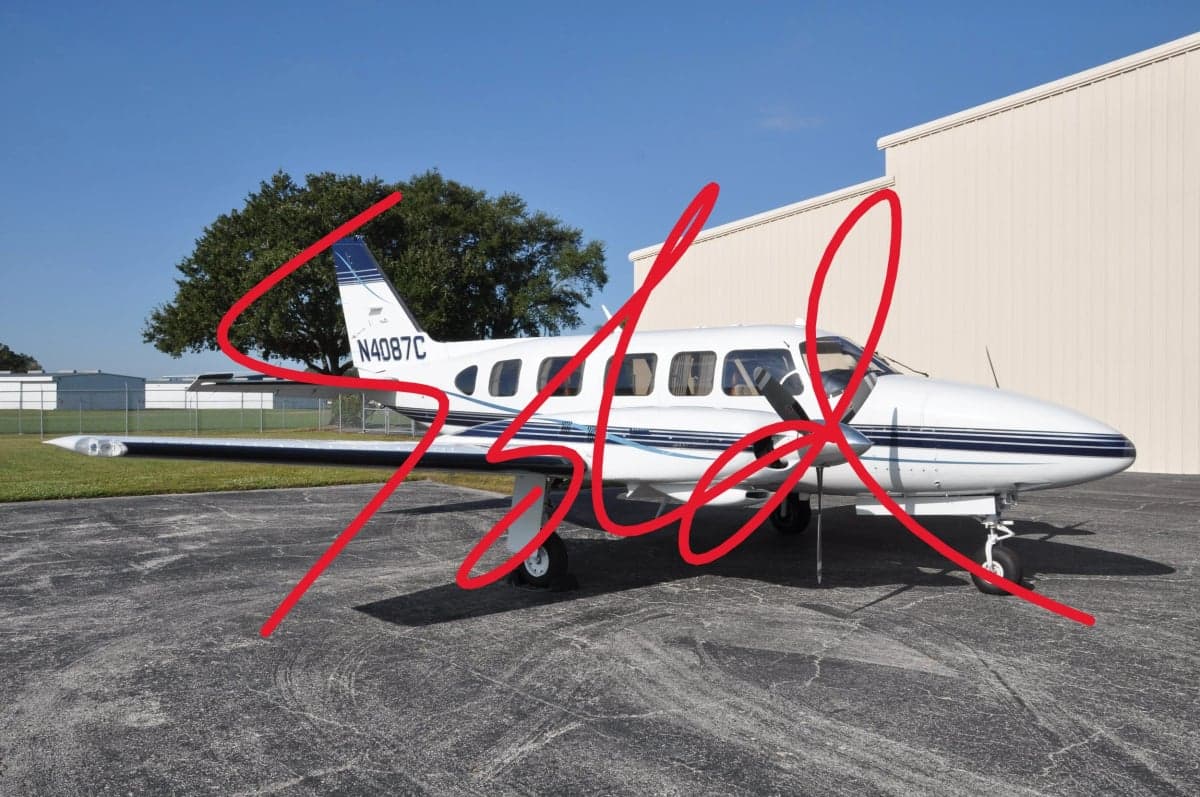 Piper PA-46 Malibu Mirage aircraft with a white and blue paint scheme parked on the tarmac.