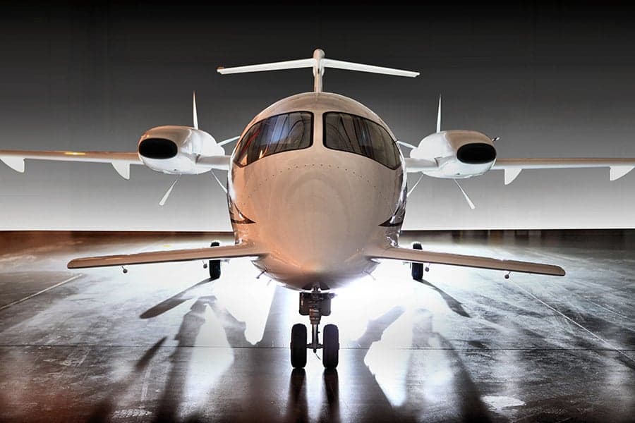 A front view of a Piaggio Avanti EVO in a hangar.