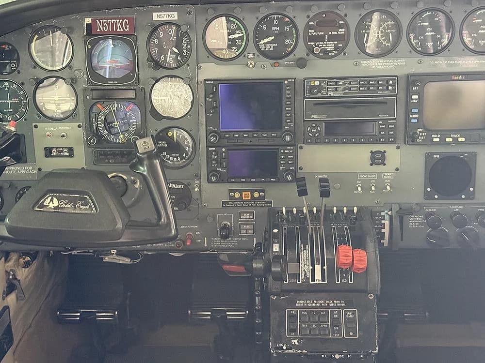 The cockpit instrument panel of N577KG, showing gauges, avionics, and the throttle quadrant.