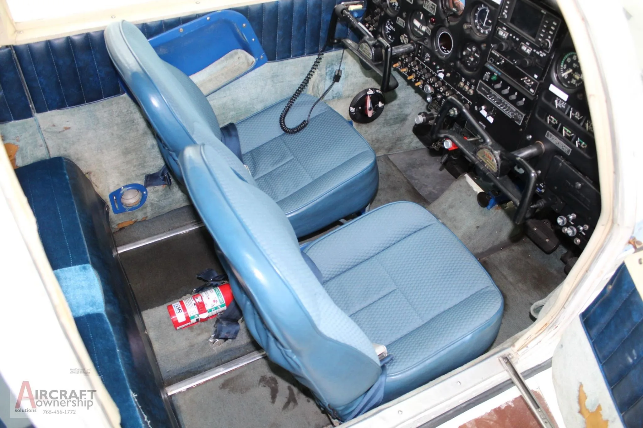 Interior view of the cockpit and front seats of a small aircraft, showing the instrument panel.