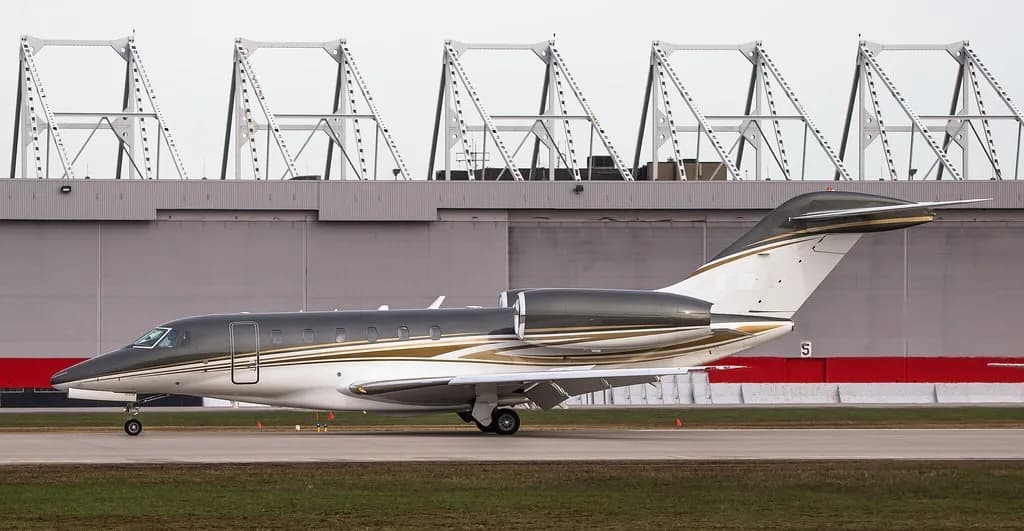 A Citation CJ3 aircraft on the tarmac with a gray and white paint scheme.