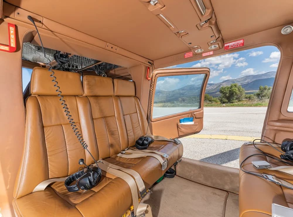 Interior view of the helicopter cabin with brown leather seats.