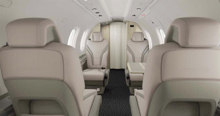 A view of the interior cabin of a Pilatus PC-12 aircraft, showing the seating arrangement.