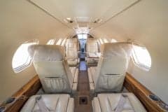 The interior of a Cessna Citation CJ1+ aircraft, showing the seating arrangement and cabin details.