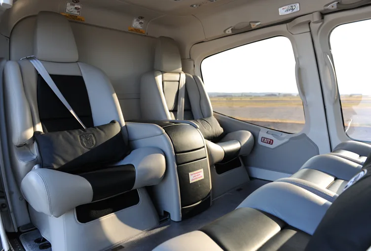 The interior of a helicopter with gray leather seats.