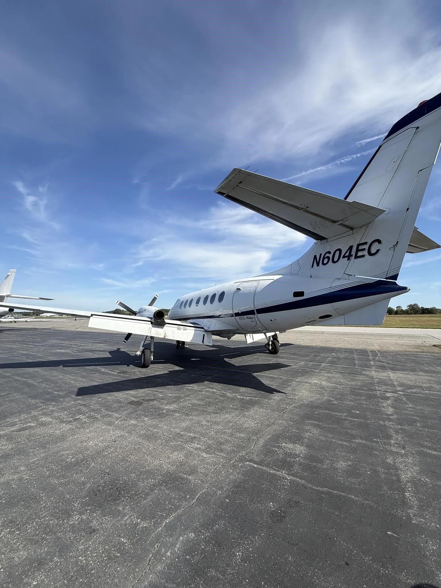 A close-up rear-quarter view of the tail and fuselage of a white Jetstream 31 aircraft with blue accents, tail number N604EC.