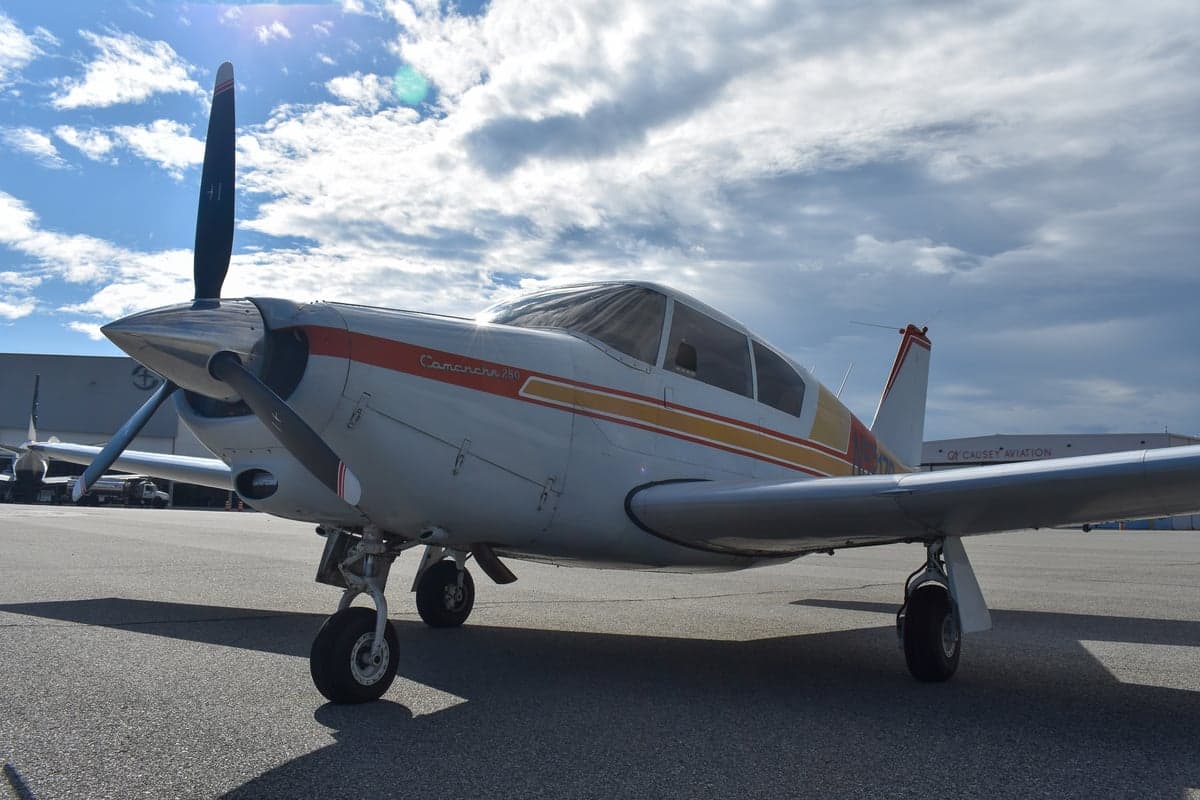 Close-up of the Piper Comanche 250 aircraft's fuselage with the model name.