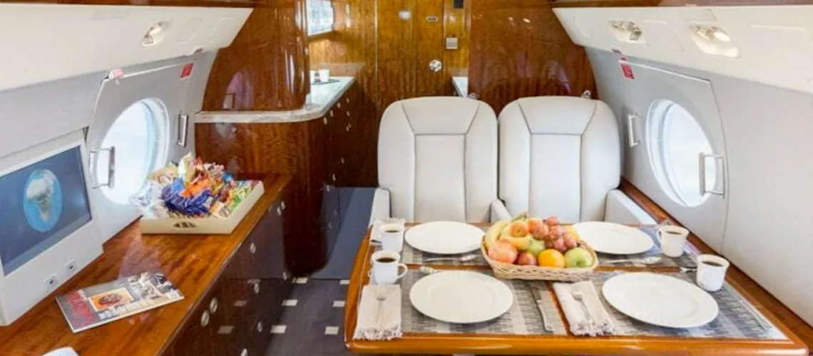 A view of the aircraft's interior with a dining table set for a meal.