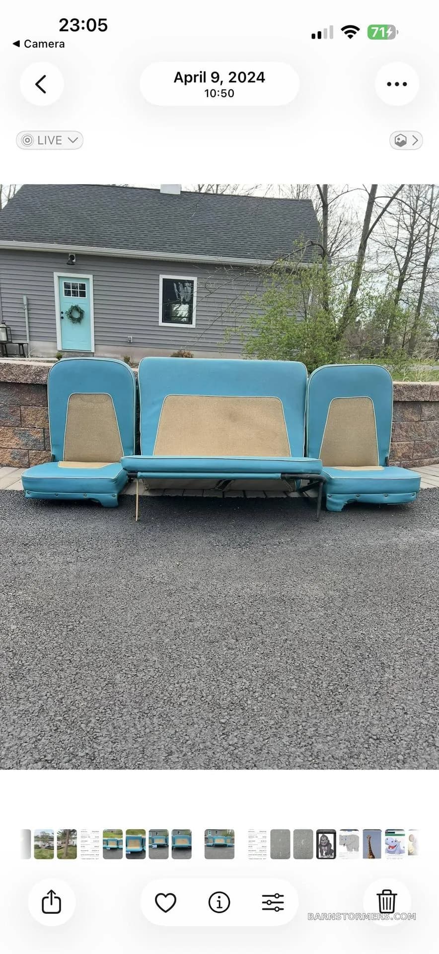 Three vintage aircraft seats, upholstered in blue and tan, placed on a paved surface outside a house.
