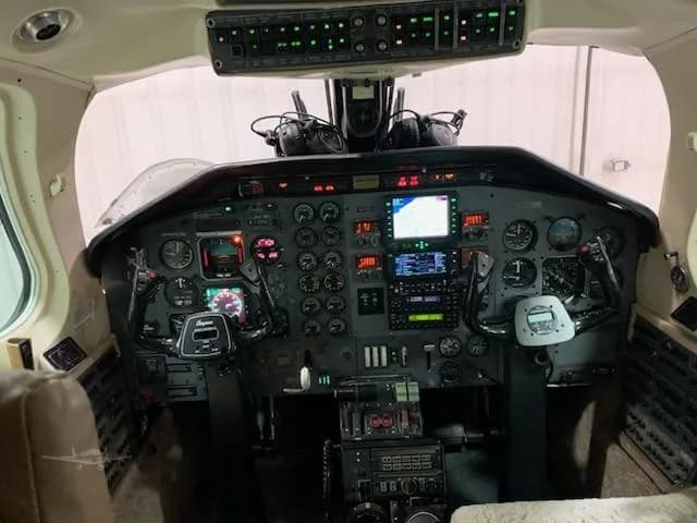 A full view of the complex instrument panel and controls in the cockpit of a twin-engine aircraft.