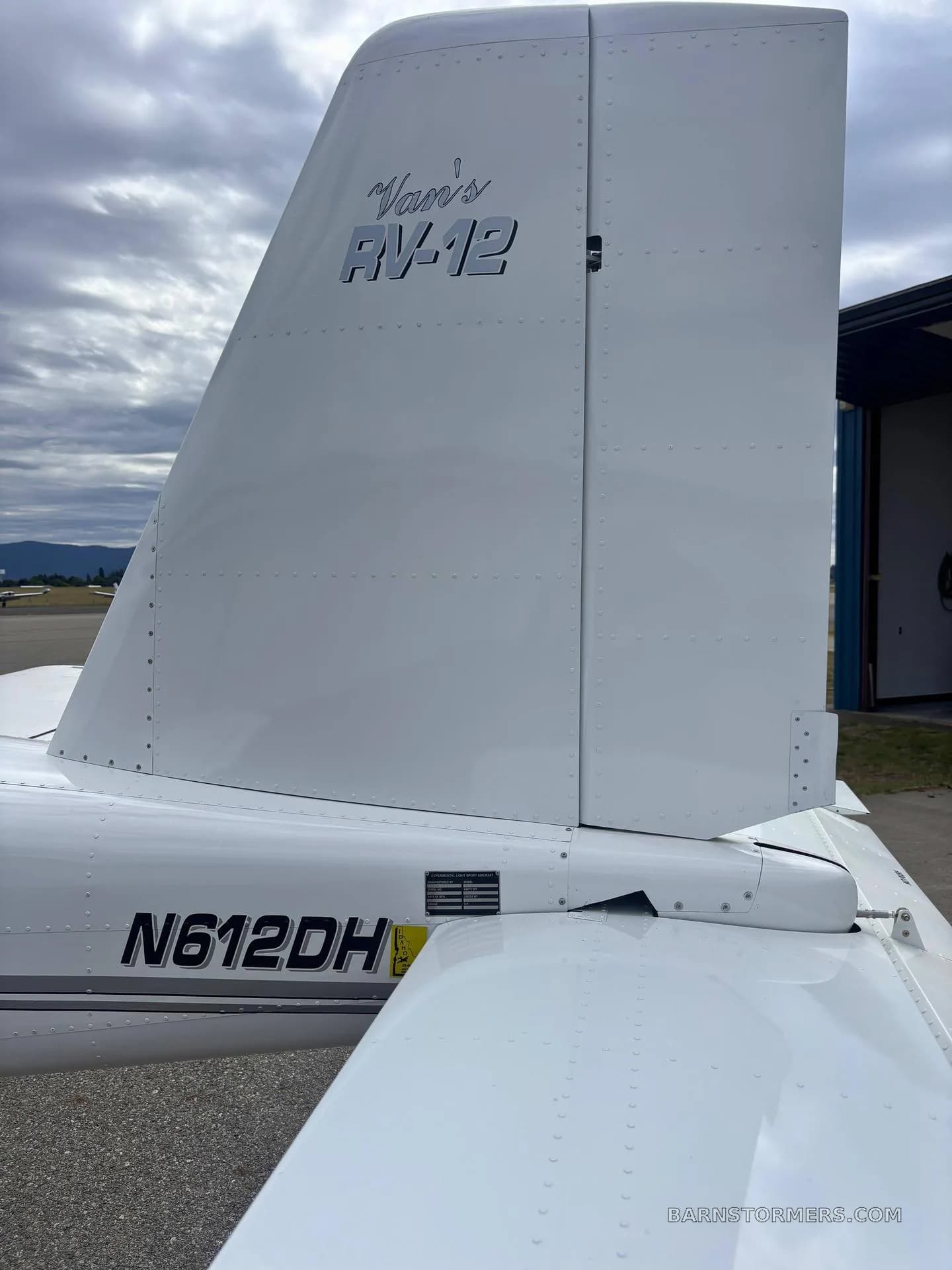 A detailed close-up of the white tail and rudder of a Vans RV-12 aircraft (N612DH) showing the registration.
