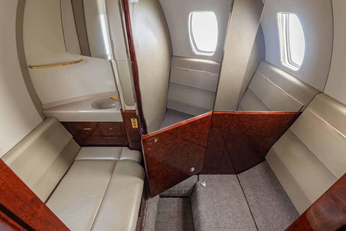 View of the aircraft lavatory with a sink and seating.