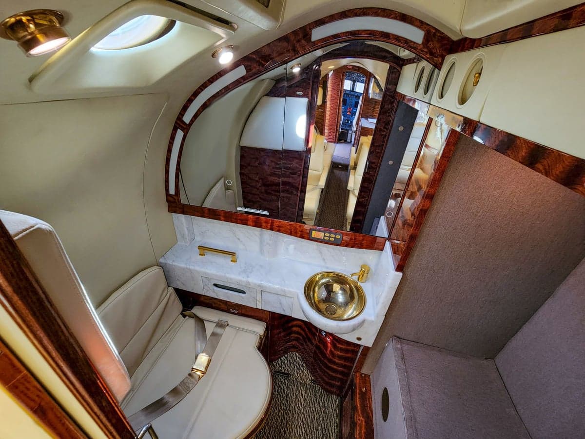 Forward view of the aircraft cabin with white leather seats.