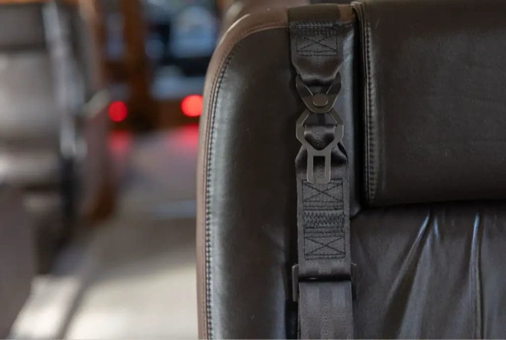 Close up of a leather seat with a seatbelt.
