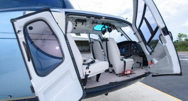 The interior of the Eurocopter AS350B3 Ecureuil features white seats and an open door.