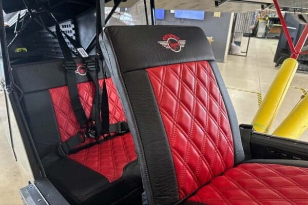 Close-up of the red and black leather seats inside the aircraft cabin.