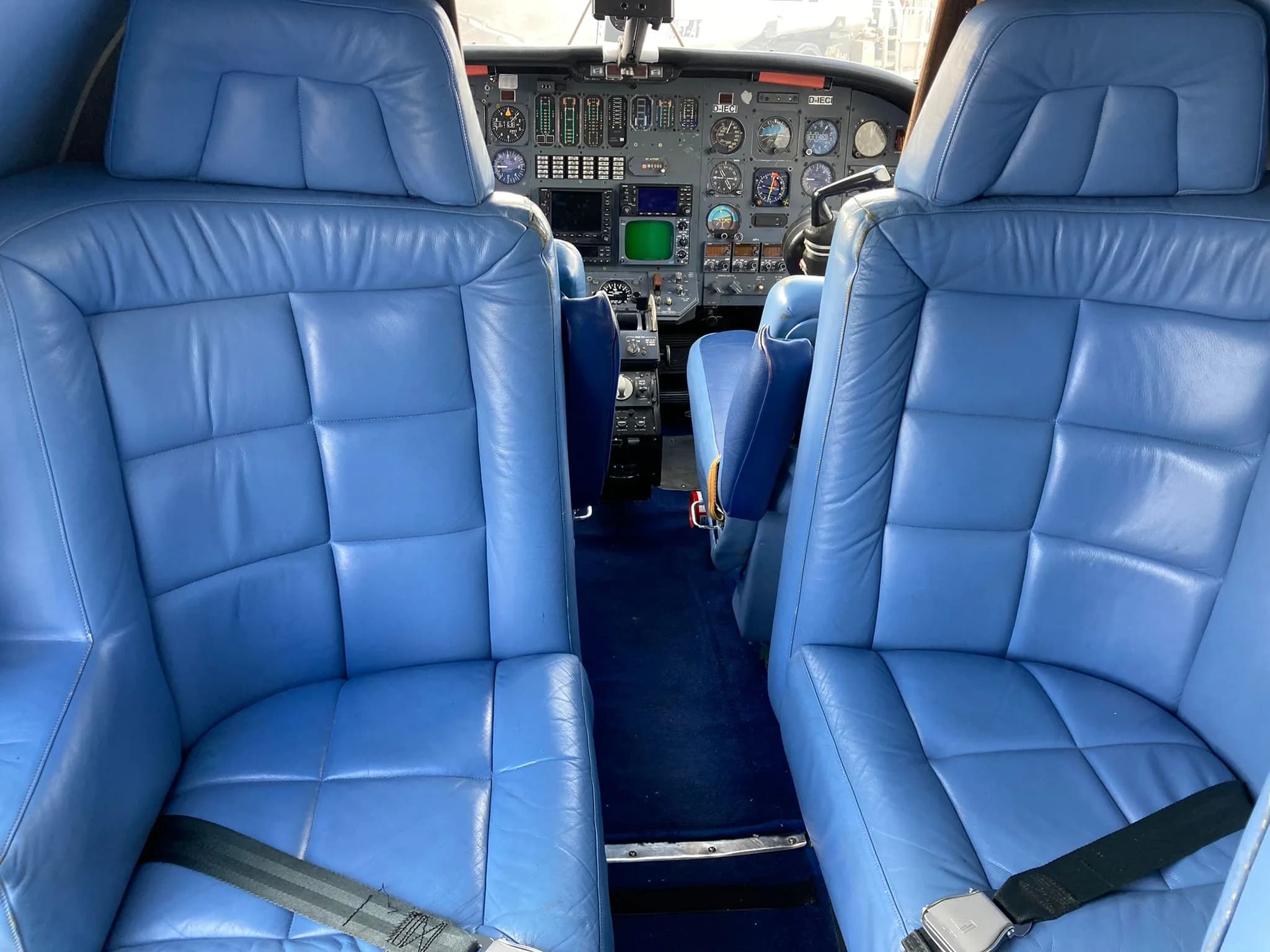 View of the cockpit and blue leather seats of the aircraft.
