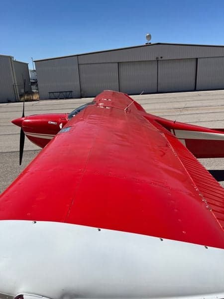 Top view of the red and white Cessna Skywagon 180's wing and fuselage.
