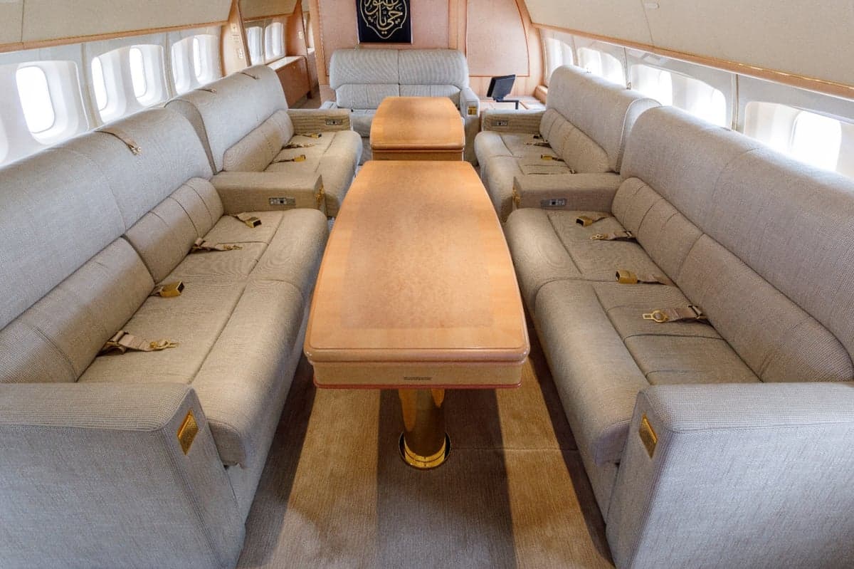 Aircraft interior with couches and a table.