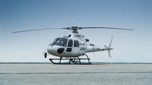 A white helicopter with registration B-744D parked on an airfield under a clear sky.