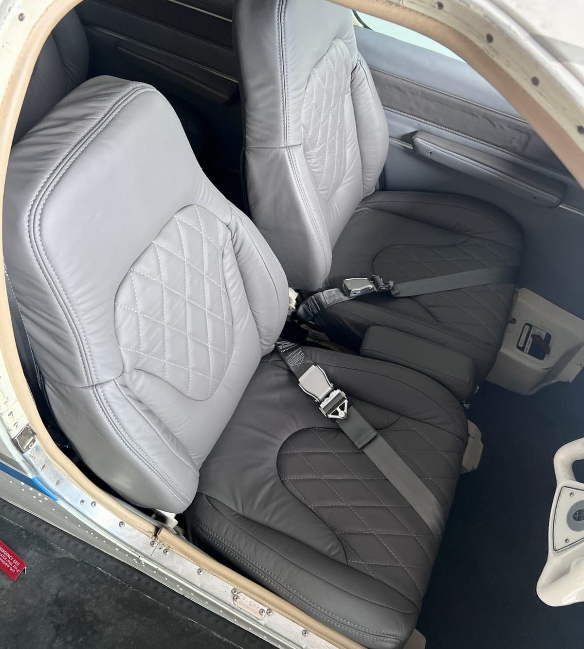 Close-up of the aircraft's interior showing gray and black leather seats with diamond stitching.