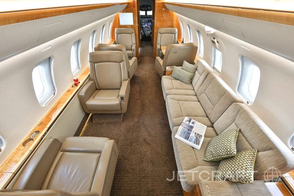 Aircraft interior featuring leather seats and a sofa.