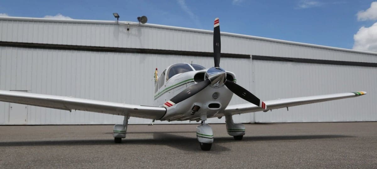 Front view of a white and green Piper Dakota aircraft on the tarmac.