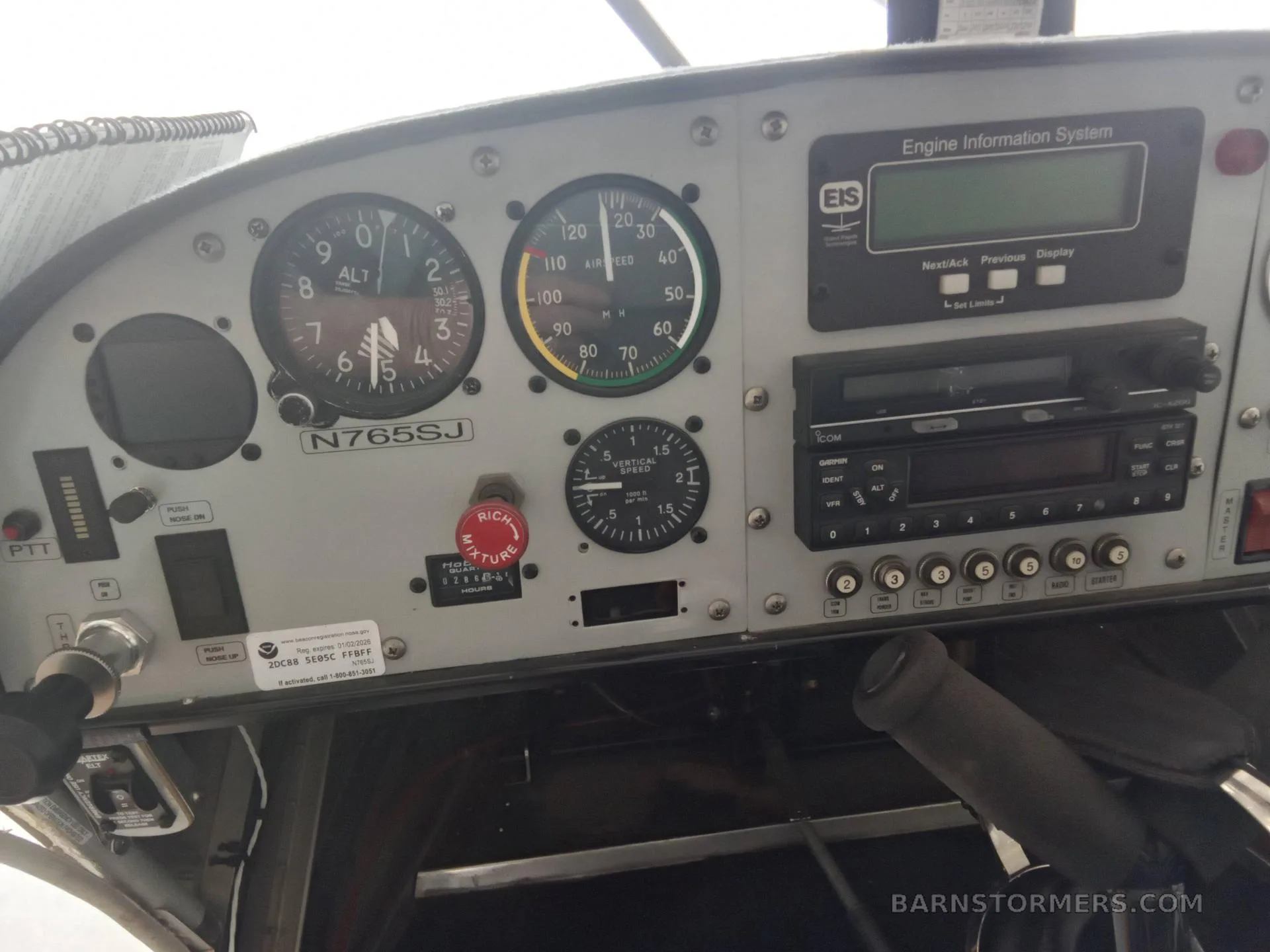 Another view of an aircraft's instrument panel, featuring an altimeter, airspeed indicator, engine information system, and radio.