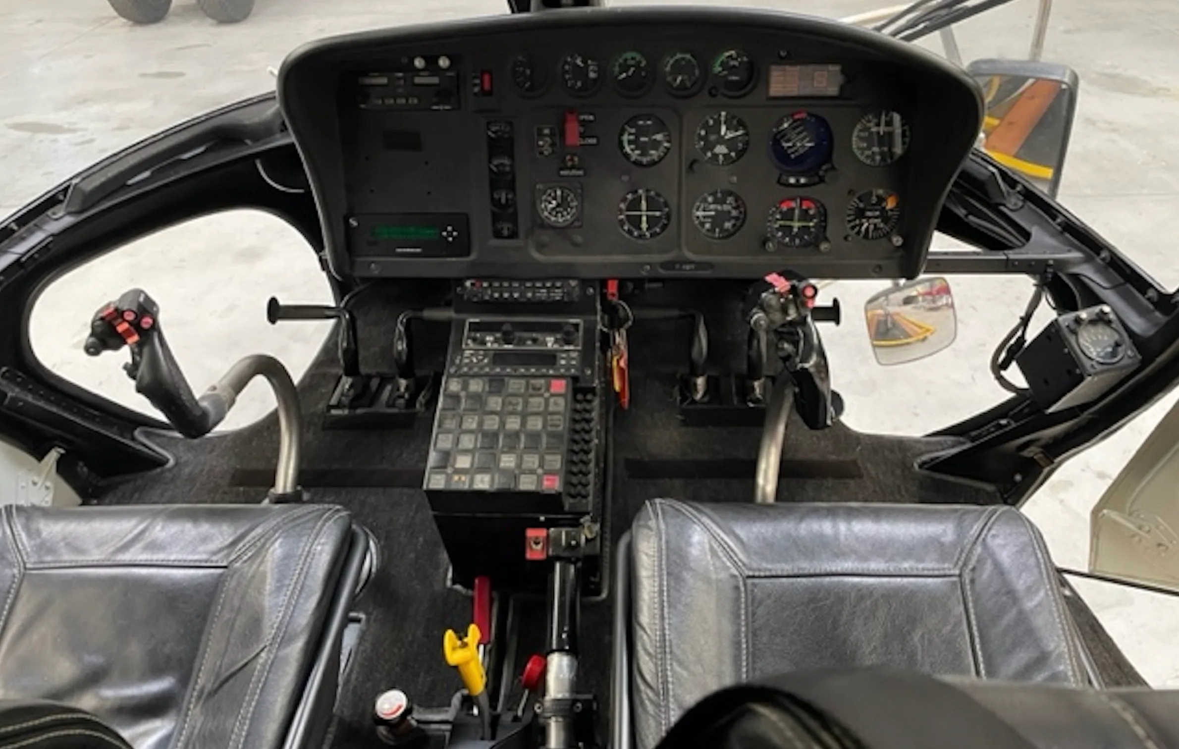 Helicopter cockpit instrument panel with various gauges and controls.