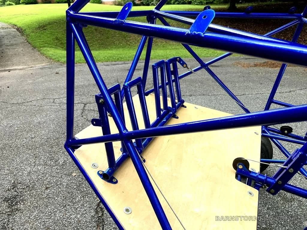 A close-up view of the blue tubular frame and wooden floor of the ultralight aircraft's interior.