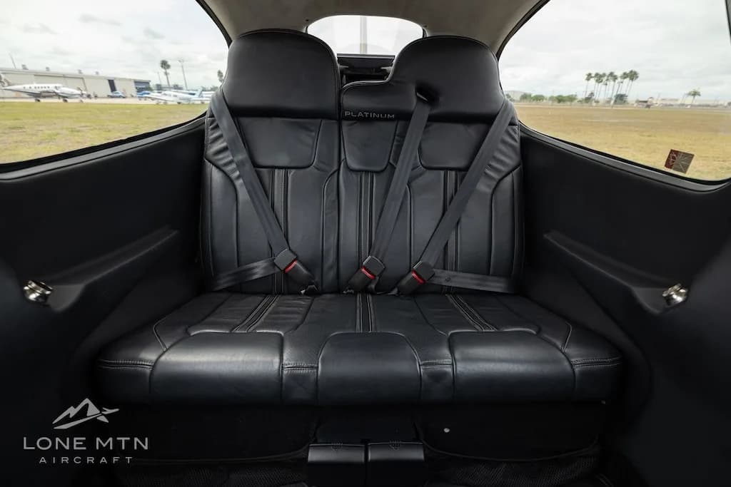 View of the black leather rear seats inside the aircraft cabin.