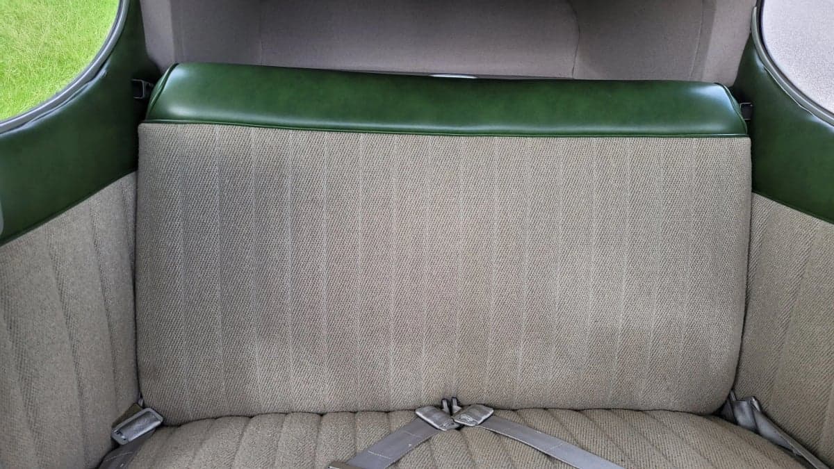 The rear bench seat of the Cessna 170 is upholstered in beige fabric with green trim.