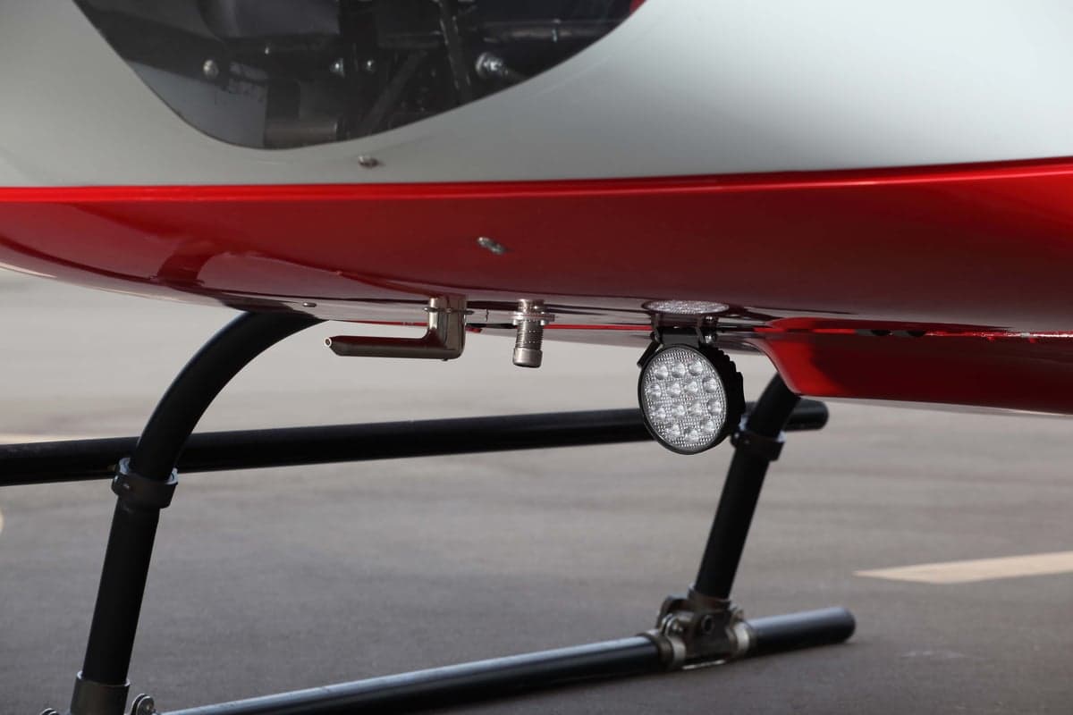 A close-up of the underside of the helicopter showing the landing gear and lights.