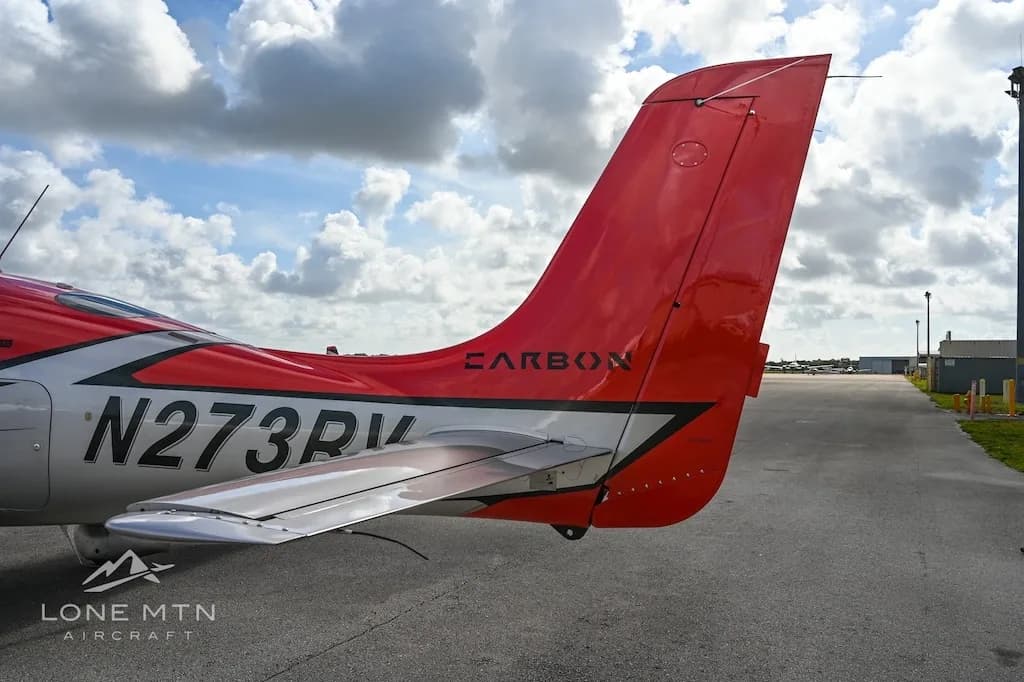 A close-up view of the red tail and horizontal stabilizer of a Cirrus SR22 aircraft, showing registration N273RV.