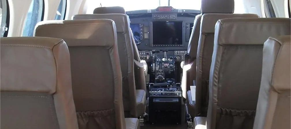 King Air cabin with leather seats and view of the cockpit.