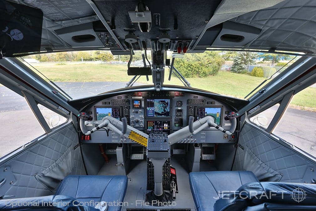 View of the aircraft cockpit with instrument panel and control sticks.