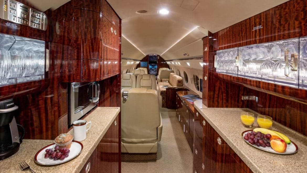 The aircraft's interior includes a galley with a microwave and coffee maker.