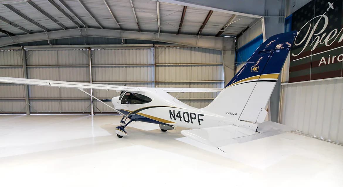 A Techman aircraft with registration N40PF is parked in a hangar with a Premier Aircraft banner in the background.