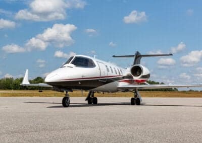 A Learjet 45XR aircraft is parked on the tarmac on a sunny day.