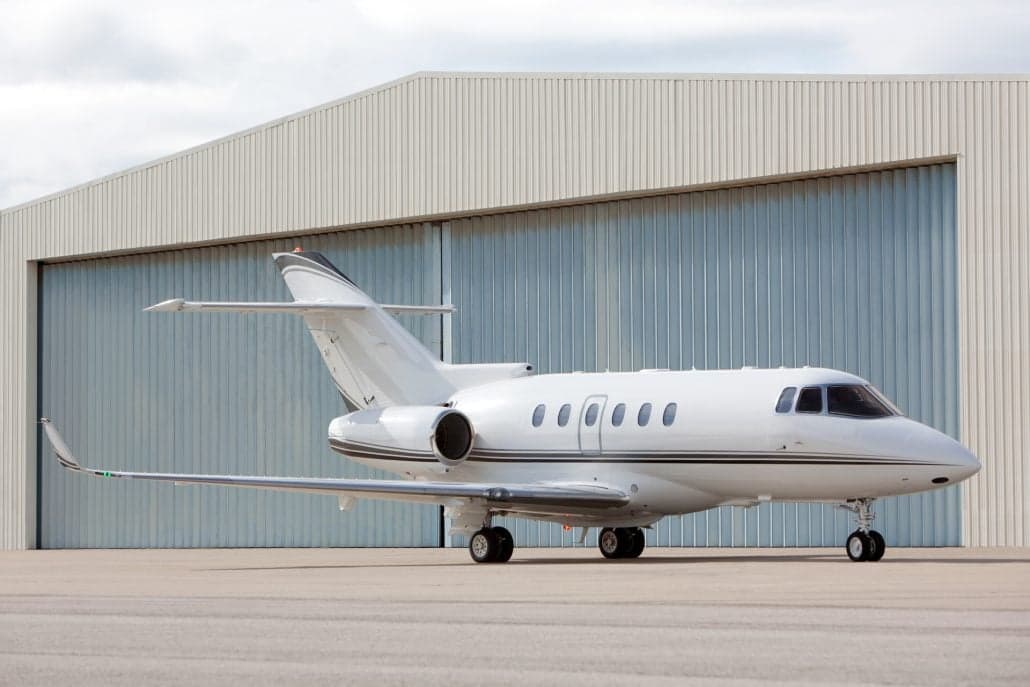 A Citation Latitude aircraft parked in front of a hangar.