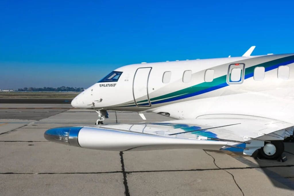 Close-up of the front section of the Pilatus PC-24 N357LT with a white and teal paint scheme.