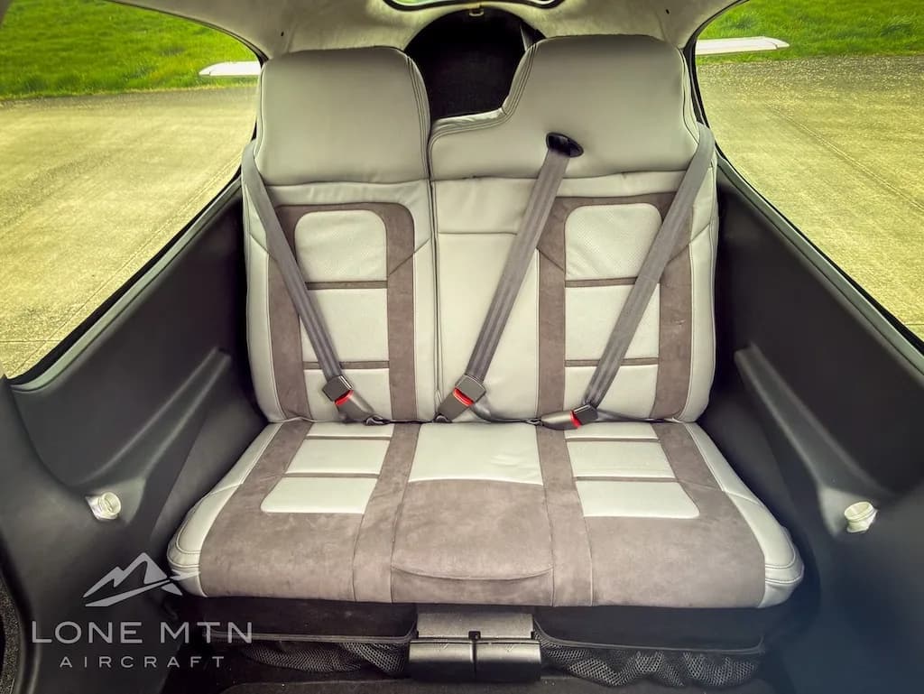 Rear view of the aircraft's two-tone grey passenger seats with seatbelts fastened.