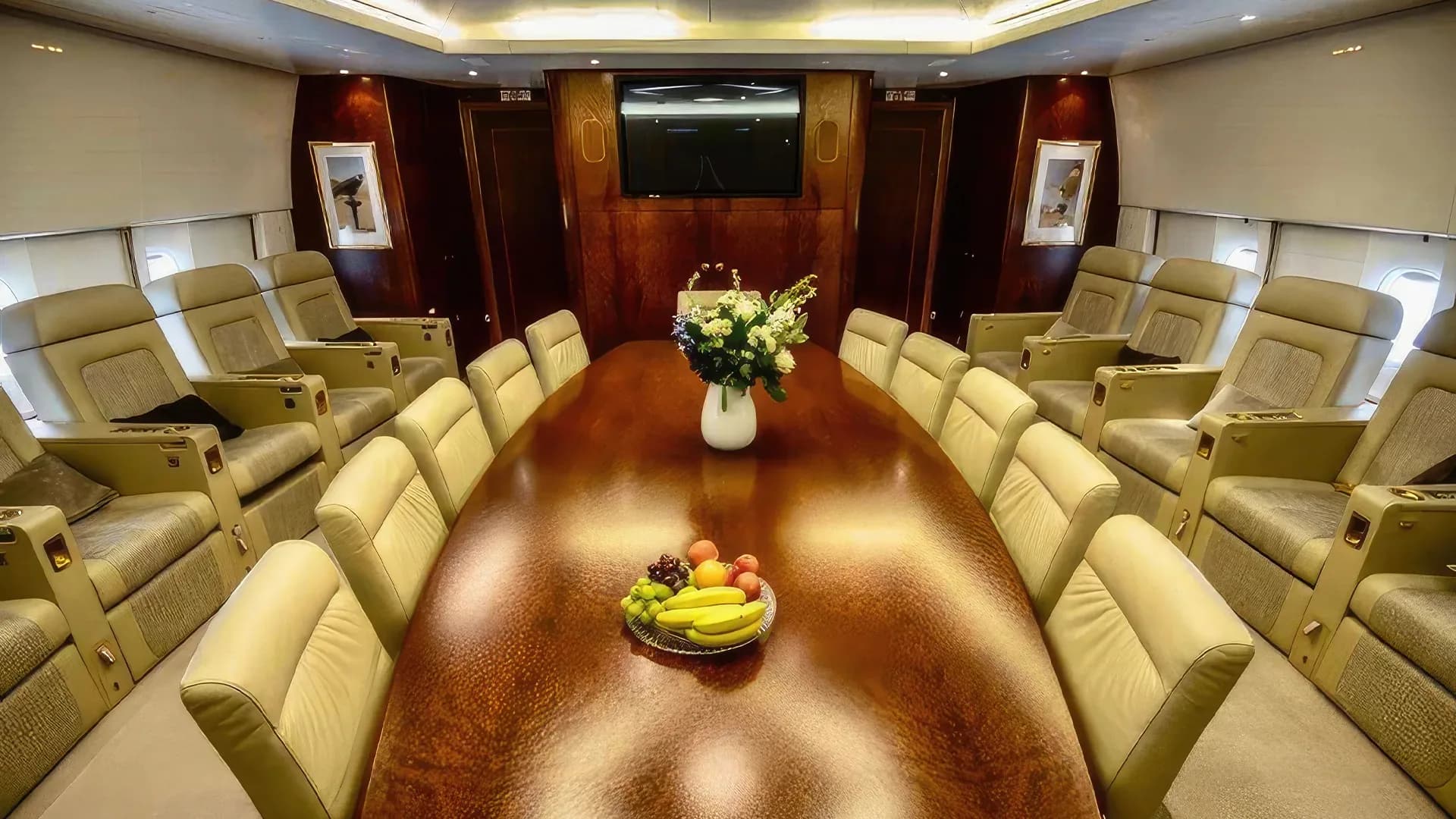 A private jet cabin with a long table and many seats.